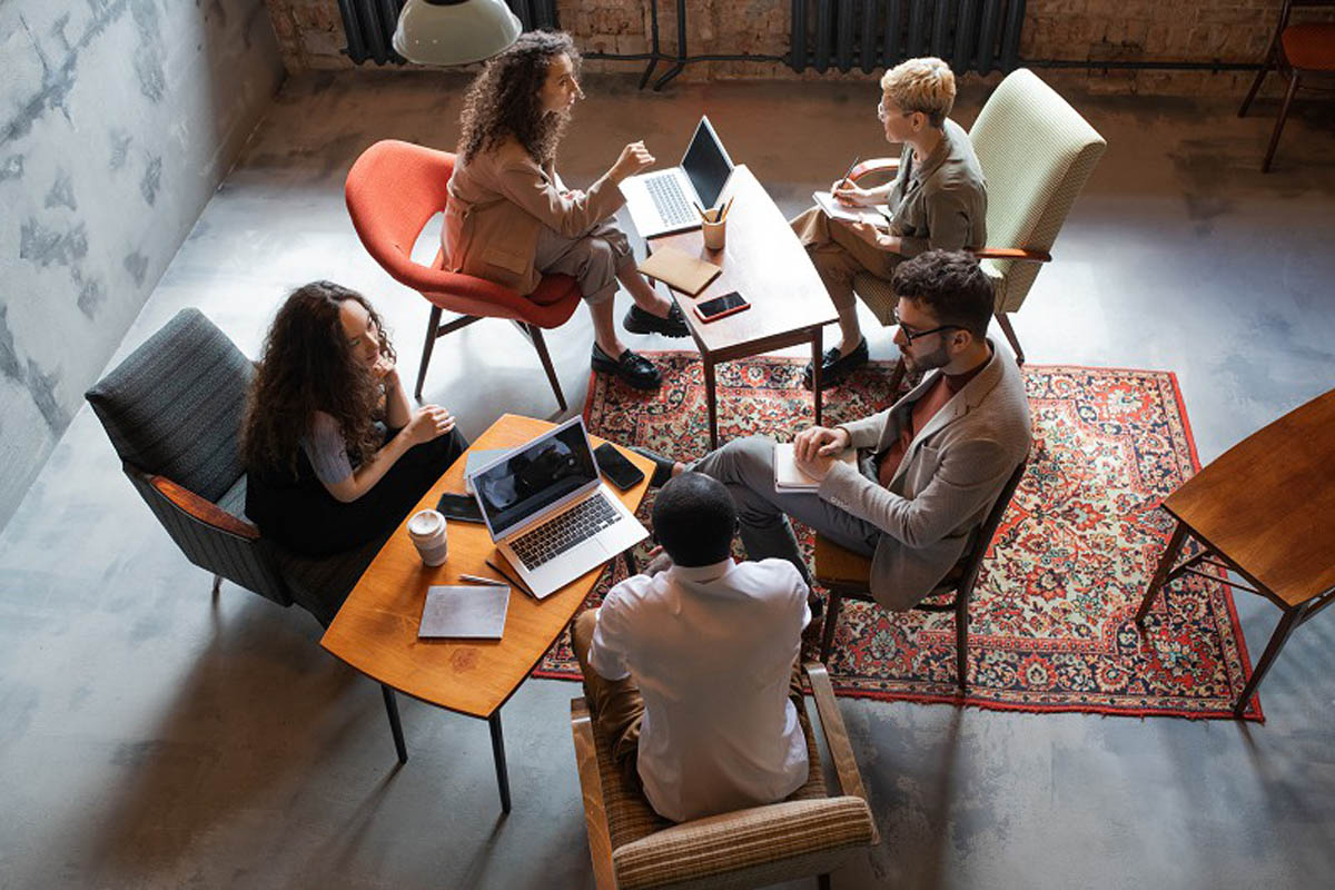 Several intercultural business people interacting by tables