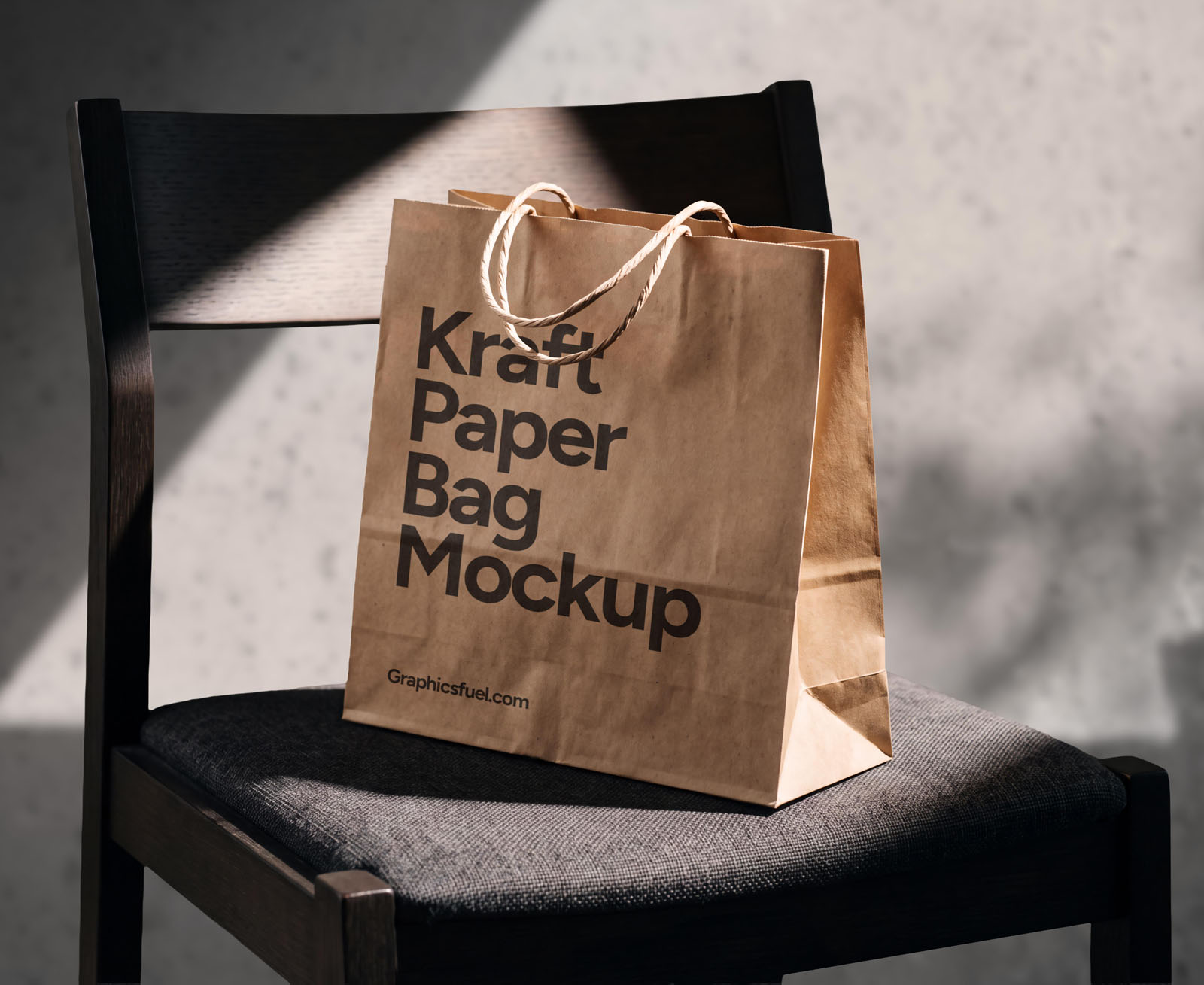 Kraft paper bag mockup on a dark wooden chair in direct sunlight