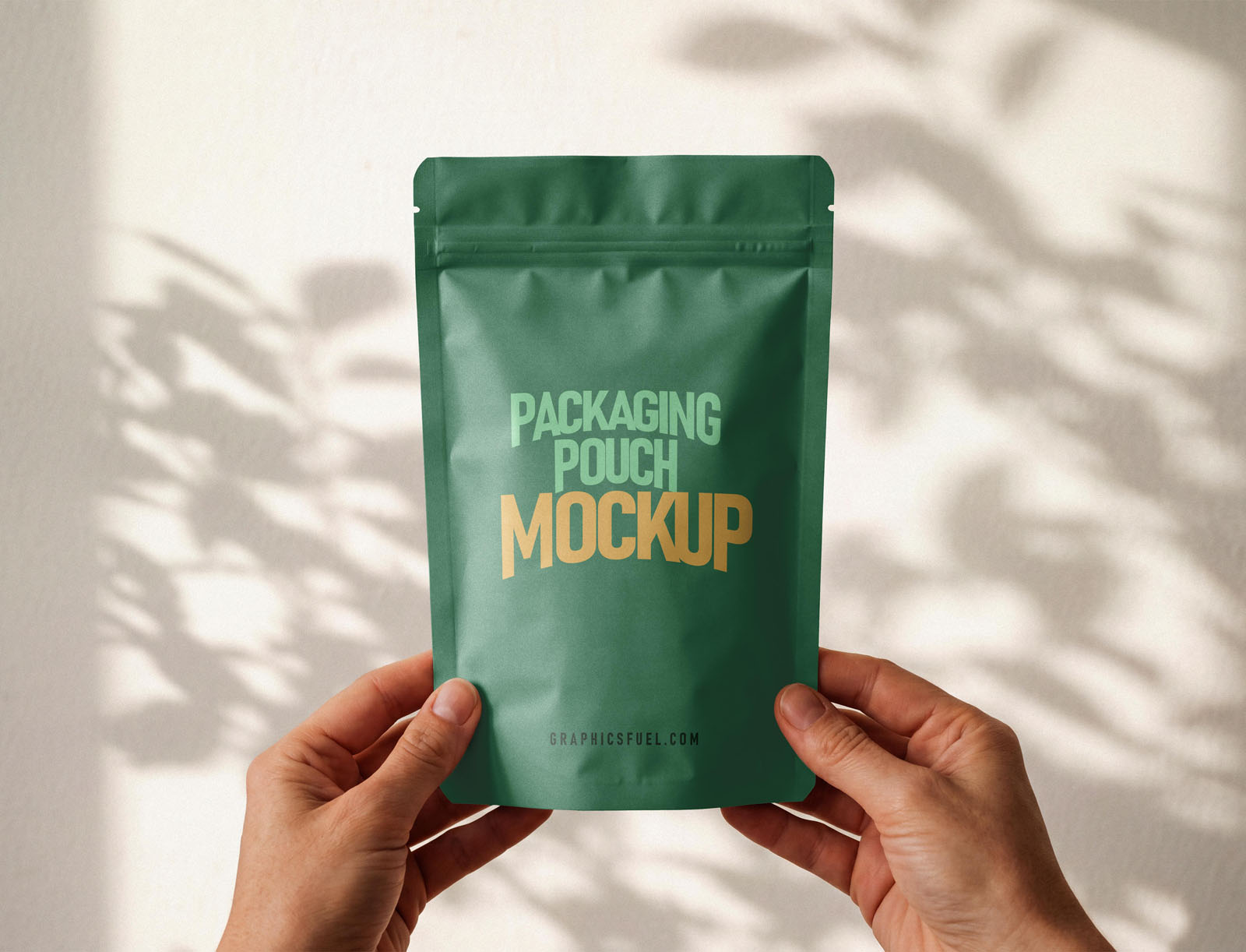 Two hands holding a green stand-up packaging pouch mockup, front view