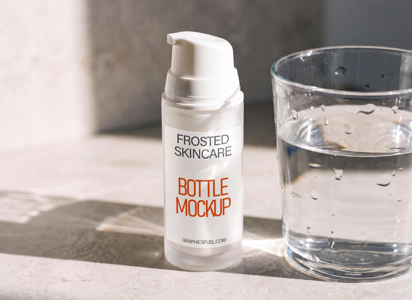 Skincare pump bottle mockup beside a glass of water on a bright surface