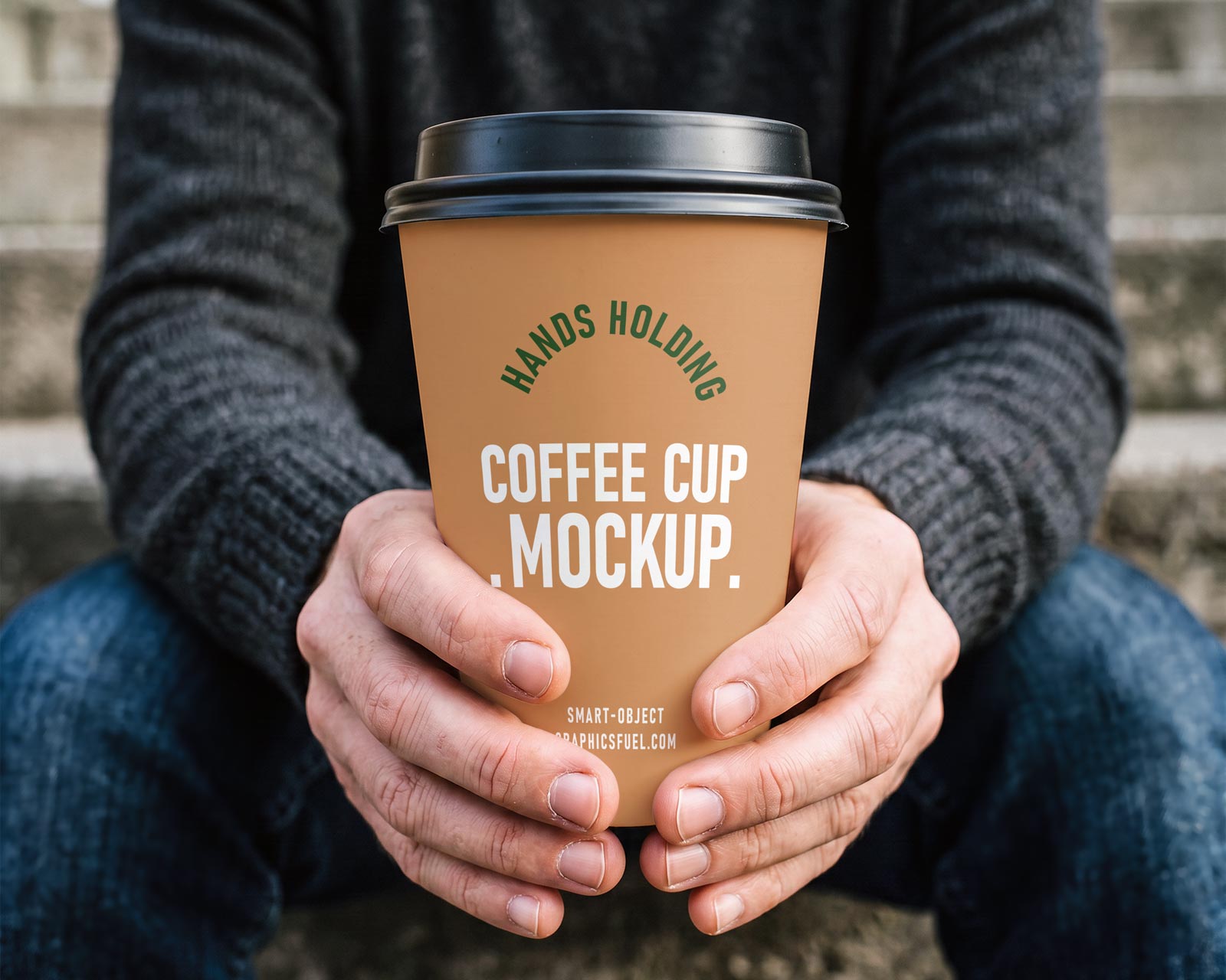 Hands holding a paper coffee cup mockup outdoors on concrete steps
